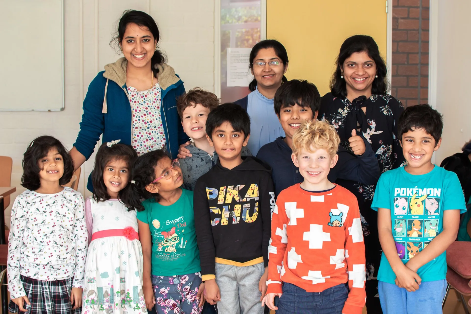 LearnNJoy teachers and a happy group of children smiling together in the classroom